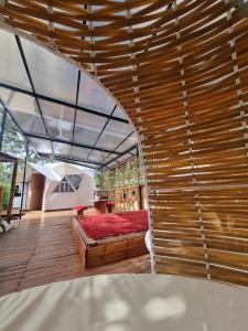 um quarto com uma cama num piso de madeira em Domos de Glamping con Jacuzzi y Piscina en San Rafael Frente al charco la Cristalina em San Rafael