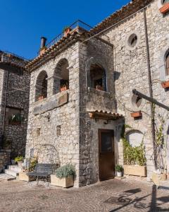 un bâtiment en pierre avec un banc devant lui dans l'établissement Al Piccolo Borgo Locanda Con Alloggio, à Castelnuovo Parano
