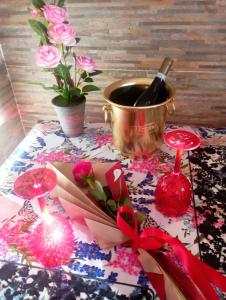 a table with a bottle of wine and a pot of flowers at CASA VACANZA LA MANSARDINA in Pavia