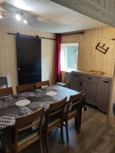 een eetkamer met een tafel en stoelen en een keuken bij Les digitales appartement in Mont-Dore