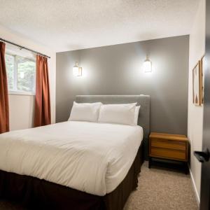 een slaapkamer met een groot bed met witte lakens en kussens bij Overlander Mountain Lodge in Jasper