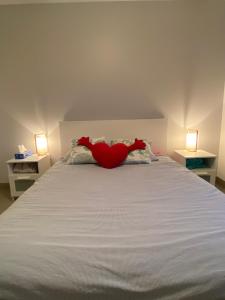een bed met een rode knuffel erop. bij Maison avec piscine, climatisée, proche plage in Roquebrune-sur-Argens