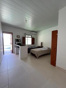 a large room with a bed and a kitchen at Casa Mangue in Soure