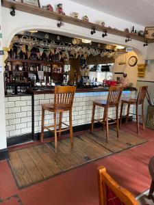 a bar with four wooden chairs and a counter at The New Inn in Cinderford