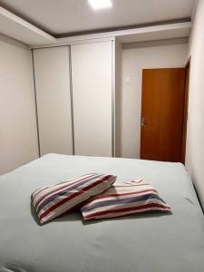 1 dormitorio con 2 almohadas en una cama en Casa em Campo Grande com piscina, en Campo Grande