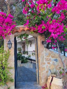 an entrance to a garden with pink flowers at Tolo at sea - Nova in Tolo