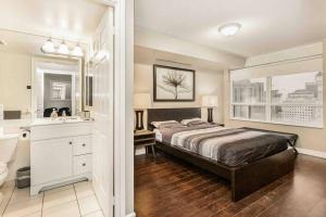 - une chambre avec un lit et une salle de bains pourvue d'un lavabo dans l'établissement High-end 2BR/2BA Condo+Views!-Steps from SQ1 Mall, à Mississauga