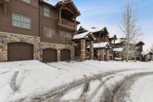 a snow covered driveway in front of a house at Slopeside 129 in Whitefish