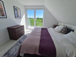 a bedroom with a large bed and a large window at "Dom w Zieleni" in Sulmice