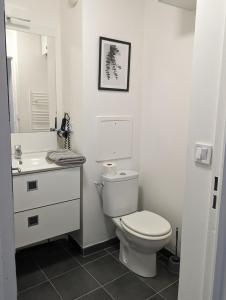 a white bathroom with a toilet and a sink at Escale à Disneyland Paris in Montévrain +4 photos
