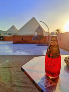 een fles cocacola bovenop een tafel bij Energy Of Pyramid Hotel in Caïro