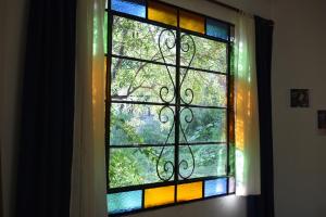 a stained glass window with a view of a tree at Glamping Octógono in Río Ceballos
