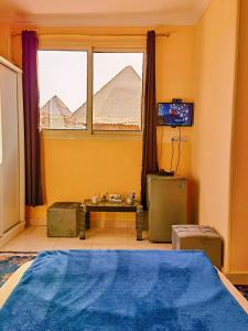 a bedroom with a large bed and a window at Energy Of Pyramid Hotel in Cairo