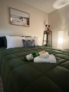 ein grünes Bett mit zwei Handtüchern und zwei Handtüchern in der Unterkunft Beautiful Siesta Key home in Sarasota