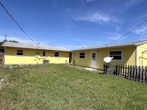 ein gelbes Haus mit einem Zaun im Hof in der Unterkunft Beautiful Siesta Key home in Sarasota