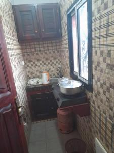 a small bathroom with a sink and a window at Coubaahala in Yaoundé