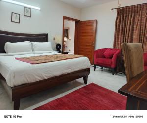 a bedroom with a bed and a desk and a chair at Palladium Executive in Islamabad