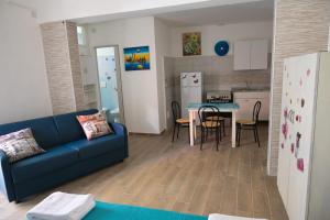 een woonkamer met een blauwe bank en een keuken bij Casa vacanze Elvy e Uccio 2 in Nardò