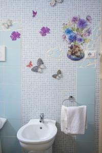 een badkamer met een wastafel en bloemen aan de muur bij Casa vacanze Elvy e Uccio 2 in Nardò