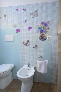 een badkamer met een toilet en vlinders aan de muur bij Casa vacanze Elvy e Uccio 2 in Nardò