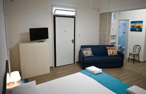 een woonkamer met een blauwe bank en een televisie bij Casa vacanze Elvy e Uccio 2 in Nardò