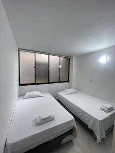 two beds in a room with two windows at Apartamento 202 in Itagüí