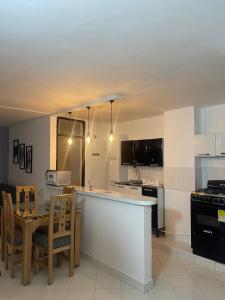 a kitchen with a counter and a table with chairs at Apartamento 202 in Itagüí