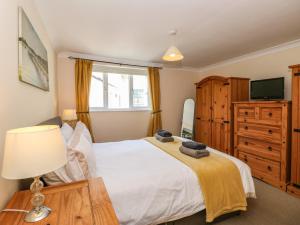 a bedroom with a bed and a dresser and a television at Inglewood in Keswick