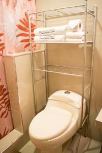 a bathroom with a toilet and some towels at HOTEL PACHAKUTEQ in Machu Picchu