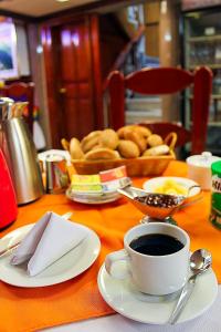 a table with a cup of coffee and a basket of bread at HOTEL PACHAKUTEQ in Machu Picchu
