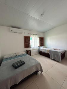 a bedroom with two beds and a window at Casa Mangue in Soure +66 photos