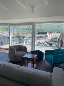 a living room with a couch and chairs and a large window at Das Anton in Gmunden