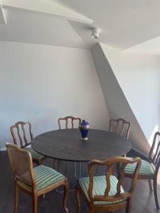 a dining room table with chairs and a vase on it at Das Anton in Gmunden