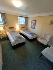 ein Hotelzimmer mit 2 Betten und einem Stuhl in der Unterkunft Arsalir Guesthouse Vik B&B in Vík