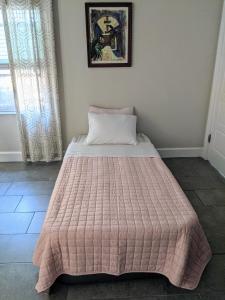 オーランドにあるPrivate Access Suite in Family Homeのピンクの毛布が備わるドミトリールームのベッド1台分です。