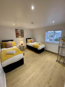 a bedroom with two beds and a window at Cosy House Accommodation in Cheltenham