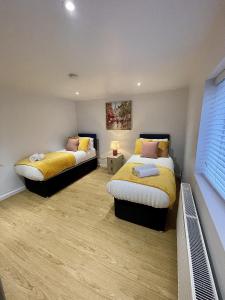 a bedroom with two beds with yellow sheets at Cosy House Accommodation in Cheltenham