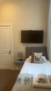 um quarto com uma cama e uma televisão na parede em Ardvaich House em Oban