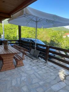 un patio con banco y sombrilla en Vikendica Kameno, en Kameno