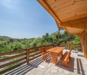 un pabellón de madera con una mesa de picnic en una terraza en Vikendica Kameno, en Kameno