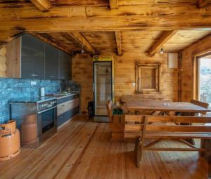 una cocina de madera con una mesa de madera en una cabaña en Vikendica Kameno, en Kameno