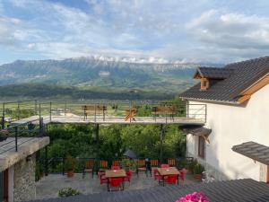 a balcony with tables and chairs and a view of a mountain at Bixhaku GuestHouse in Gjirokastër