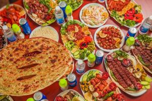 a table with many plates of food on it at Orgy Guest House in Amman