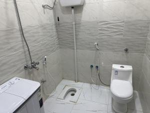 a small bathroom with a toilet and a shower at Orgy Guest House in Amman