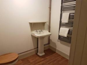 een badkamer met een wastafel, een toilet en handdoeken bij Beatshach Bothy - Speyside, Incredible location! in Dufftown