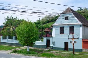 une maison bleue et blanche sur le côté d'une rue dans l'établissement Cazare La Cetate, à Moşna