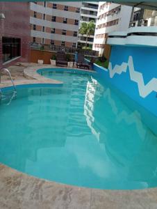a swimming pool with blue water in a building at Flat Fortaleza Saint Martin in Fortaleza