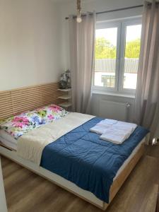 1 dormitorio con cama con sábanas azules y ventana en Apartament Jeziorna Olecko, en Olecko