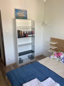 1 dormitorio con cama y estante para libros en Apartament Jeziorna Olecko, en Olecko