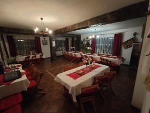 une grande salle à manger avec des tables et des chaises dans l'établissement Vila Rina, à Moieciu de Sus